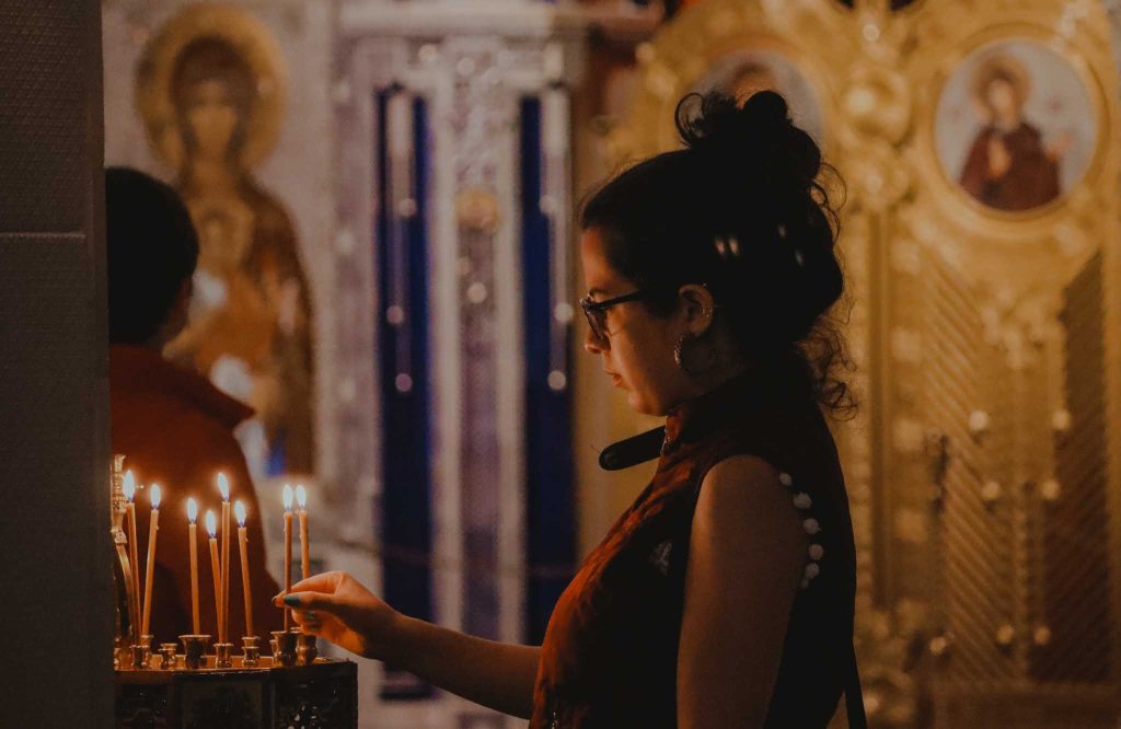 Woman holding a candle in an ancient church.