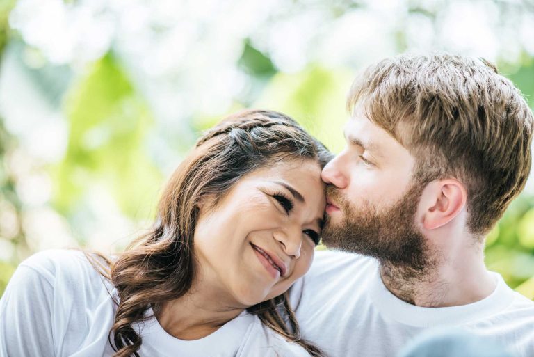 Happy diverse, engaged couple smiling.