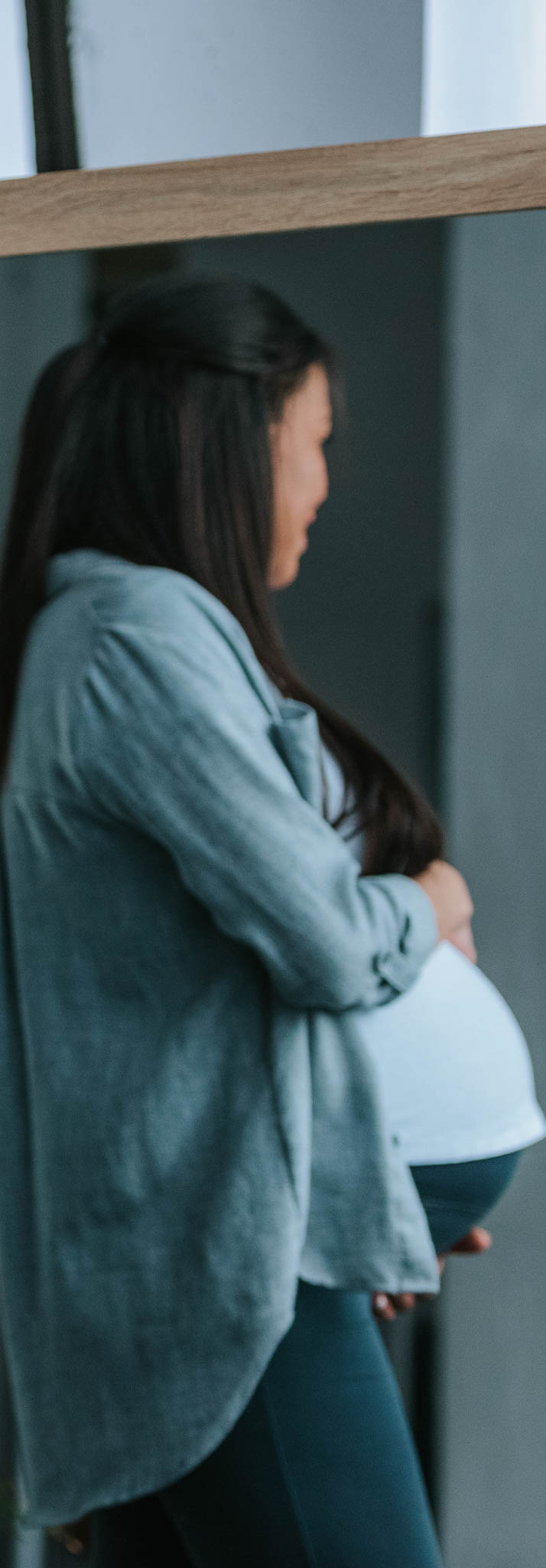 Single pregnant woman with big belly standing at mirror gets plugged in to Engedi Local outreach.