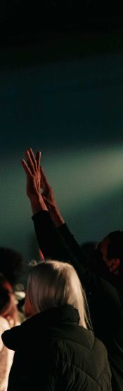 A man worshiping with lifted hands during a Sunday gathering at Engedi Church in Holland Michigan.